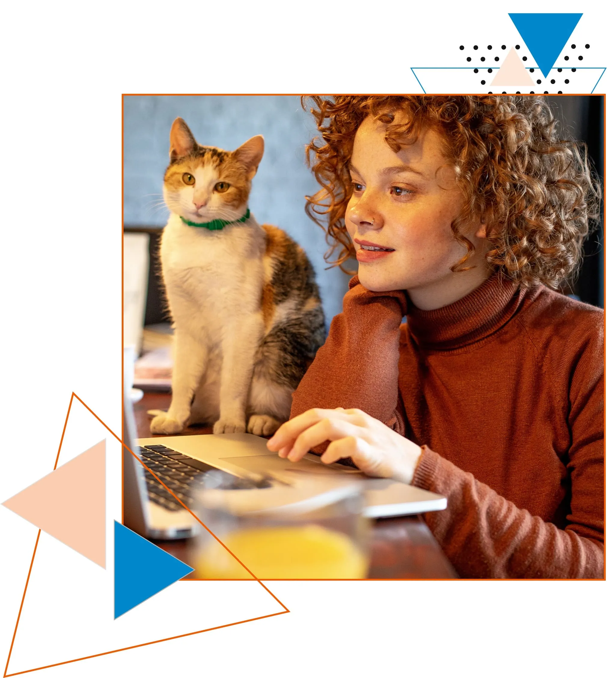 A curly-haired woman sits at a table using a laptop, with a cat perched beside her. The setting suggests a cozy remote work environment with a relaxed atmosphere, representing the possibilities available for IT professionals registered as freelancers on Jobshark's Freelancing Network